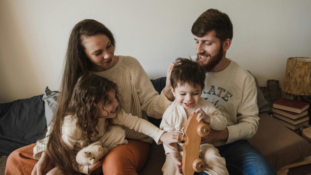 a young family sitting on a sofa together