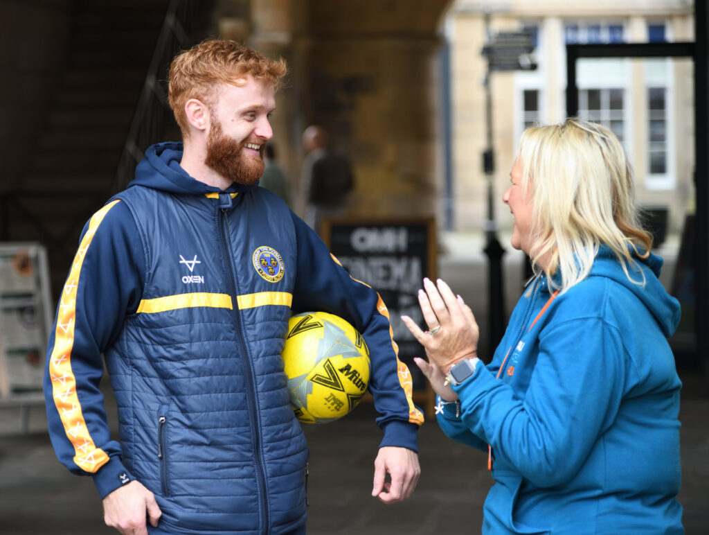 a member of the Shrewsbury Town Foundation talking with a member of the public in Shrewsbury Square