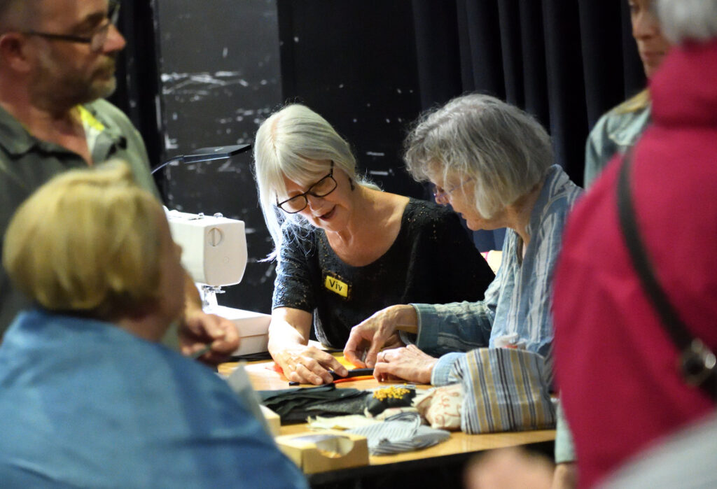 Attendees at the see, hear, remember exhibition engaging with exhibitors.